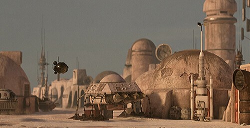 An empty street of Mon Eisley with little people in the evening